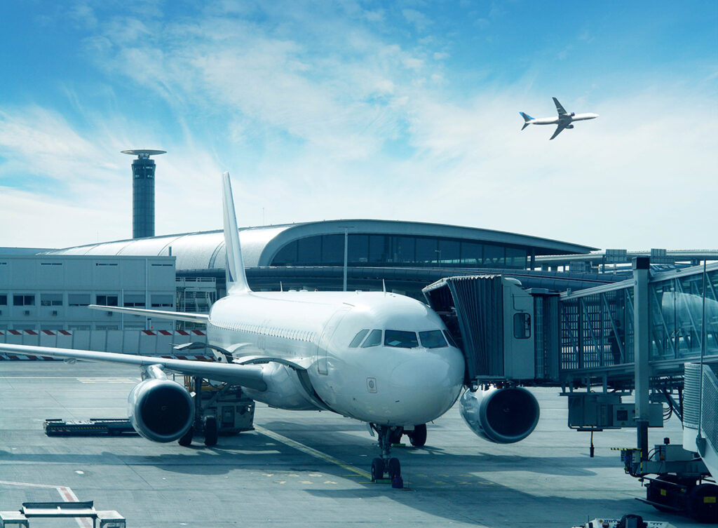 A plane is docked at Charles de Gaulle Airport on a sunny day.